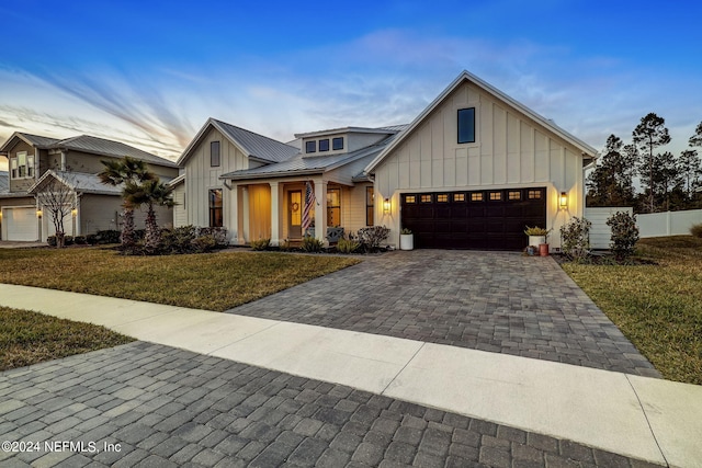 modern farmhouse style home featuring a garage and a front lawn