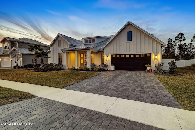 modern farmhouse style home featuring a garage and a yard