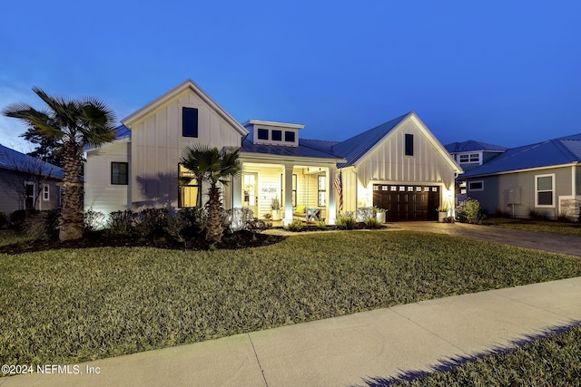 modern farmhouse with a yard and a garage