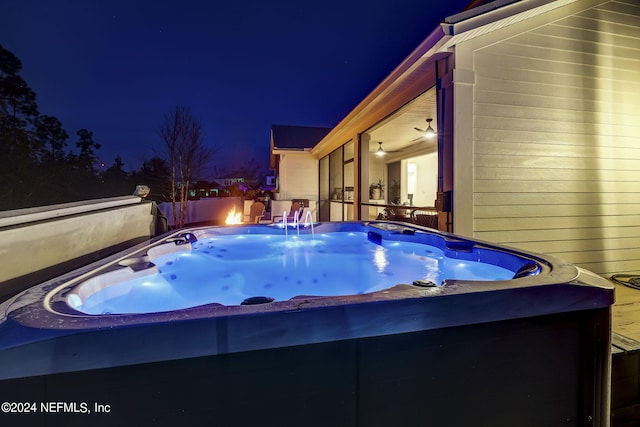 pool at night with a hot tub