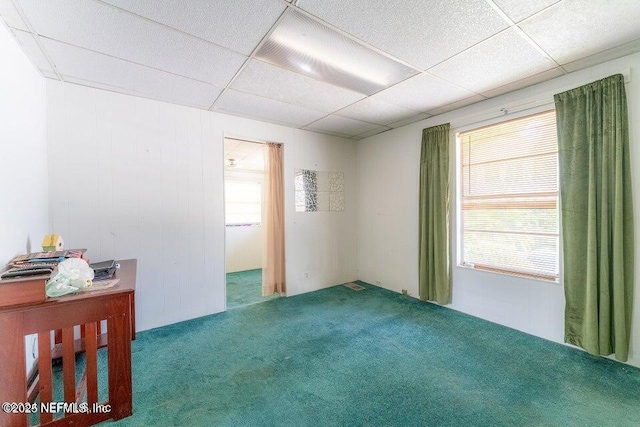 unfurnished room featuring carpet flooring and a paneled ceiling