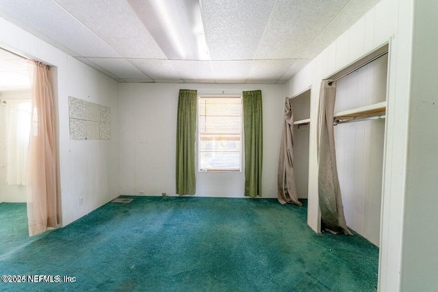 unfurnished bedroom with carpet flooring and a drop ceiling