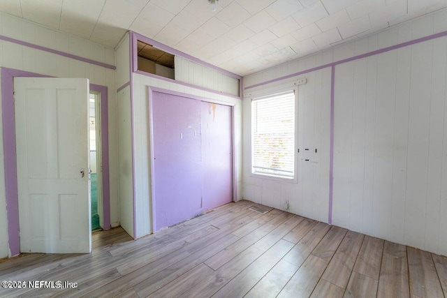 unfurnished bedroom featuring light wood-type flooring and a closet