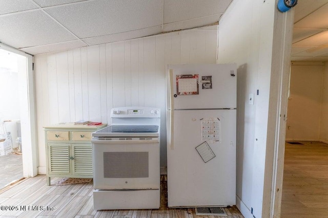 kitchen featuring white appliances, light hardwood / wood-style flooring, and a drop ceiling