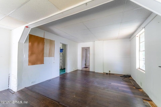 spare room featuring hardwood / wood-style flooring and a drop ceiling