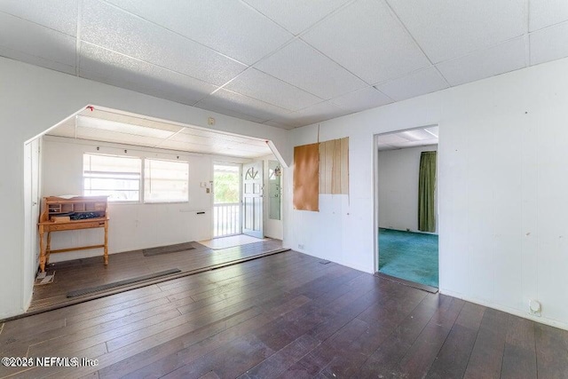 unfurnished room with dark hardwood / wood-style floors and a drop ceiling