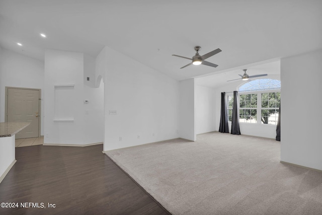 unfurnished living room featuring lofted ceiling and dark hardwood / wood-style floors