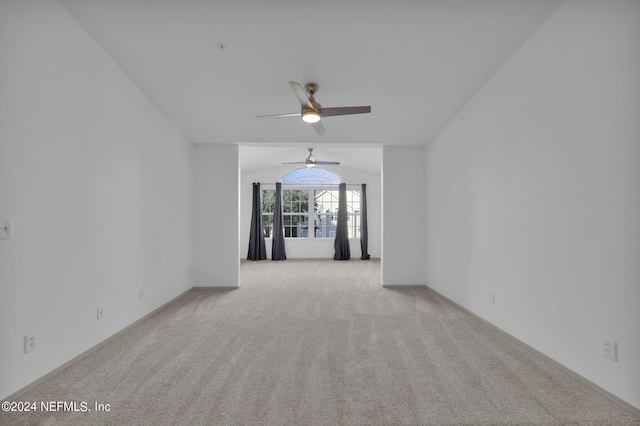 spare room featuring light colored carpet and vaulted ceiling