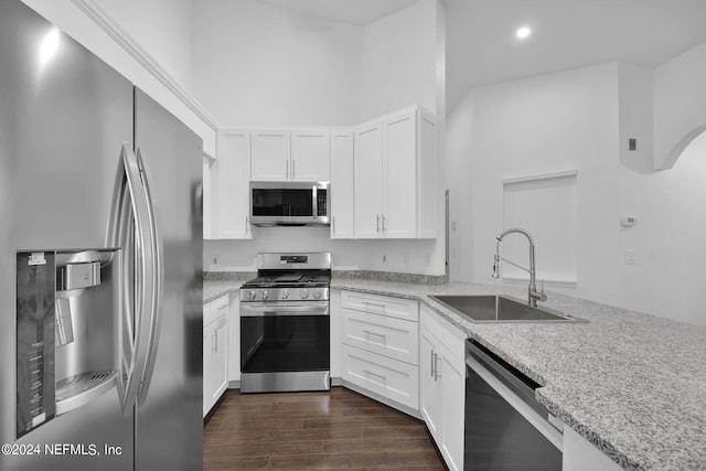 kitchen featuring white cabinetry, sink, light stone countertops, and appliances with stainless steel finishes