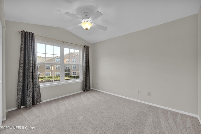 carpeted spare room with vaulted ceiling and ceiling fan