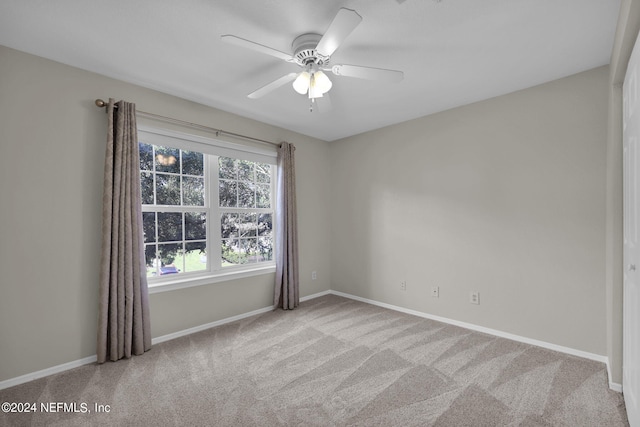 carpeted spare room featuring ceiling fan