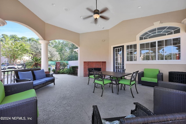 view of patio / terrace with an outdoor living space with a fireplace and ceiling fan