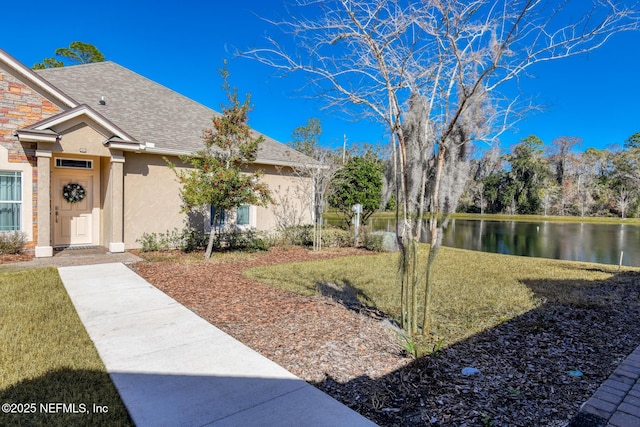 view of front of home featuring a water view and a front lawn