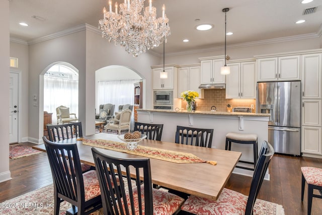 dining room featuring an inviting chandelier, crown molding, and dark hardwood / wood-style floors