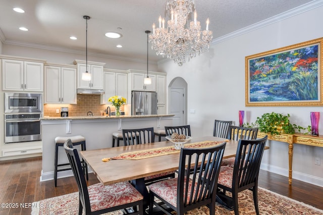 dining room with crown molding, dark wood-type flooring, and sink