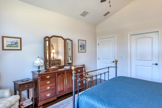 bedroom featuring vaulted ceiling, dark wood-type flooring, and a textured ceiling