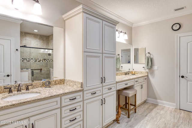 bathroom with ornamental molding, an enclosed shower, a textured ceiling, and vanity