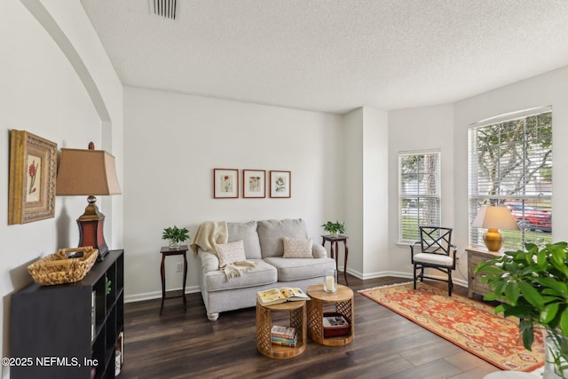 living room with dark hardwood / wood-style flooring and a textured ceiling