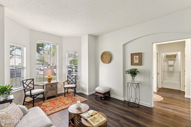 living room featuring dark wood-type flooring and a textured ceiling