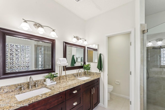 bathroom with tile patterned flooring, vanity, toilet, a shower with door, and a textured ceiling