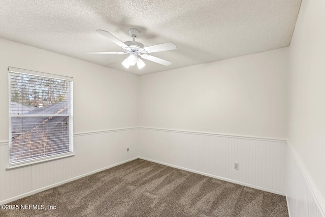 spare room featuring a textured ceiling, ceiling fan, and carpet flooring