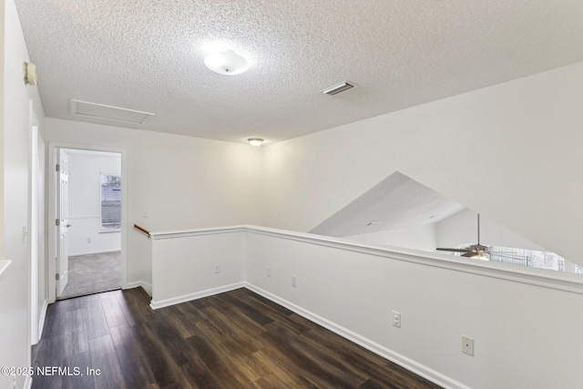 unfurnished room featuring ceiling fan, dark hardwood / wood-style floors, and a textured ceiling