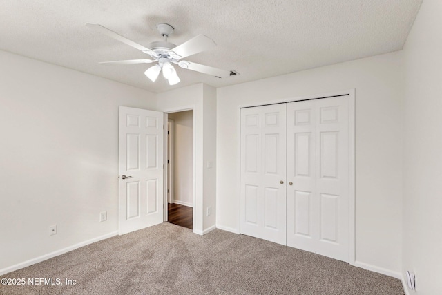 unfurnished bedroom with ceiling fan, carpet flooring, a closet, and a textured ceiling