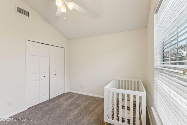 unfurnished bedroom with lofted ceiling, a closet, ceiling fan, and carpet flooring