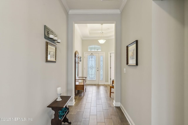 interior space featuring visible vents, baseboards, a tray ceiling, ornamental molding, and dark wood-style floors