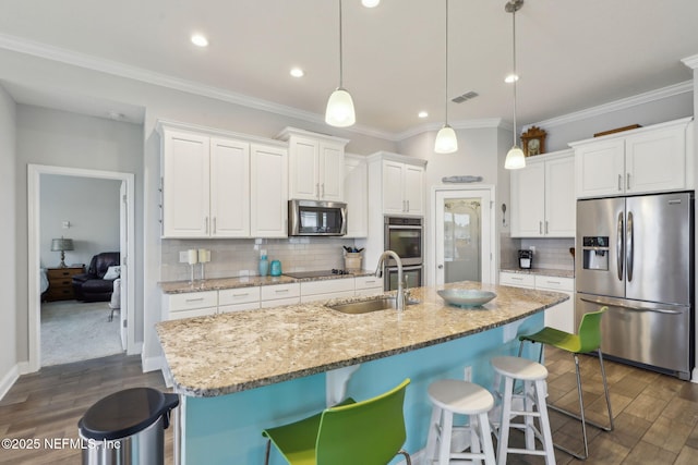 kitchen with dark wood-style floors, visible vents, stainless steel appliances, and a sink