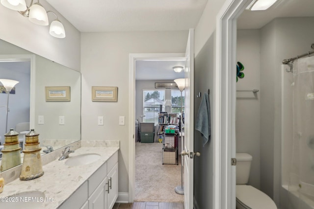 full bathroom with toilet, double vanity, a shower with curtain, and a sink