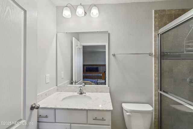 ensuite bathroom featuring toilet, a stall shower, ensuite bath, and vanity