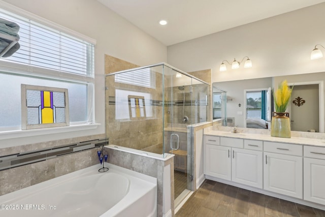 bathroom with a healthy amount of sunlight, connected bathroom, a shower stall, and a garden tub