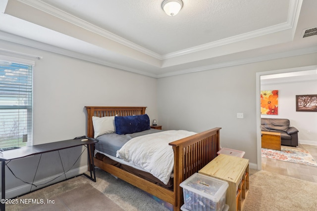 bedroom with visible vents, a raised ceiling, baseboards, and ornamental molding