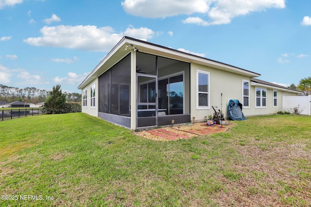 back of house featuring a yard, a fenced backyard, and a sunroom