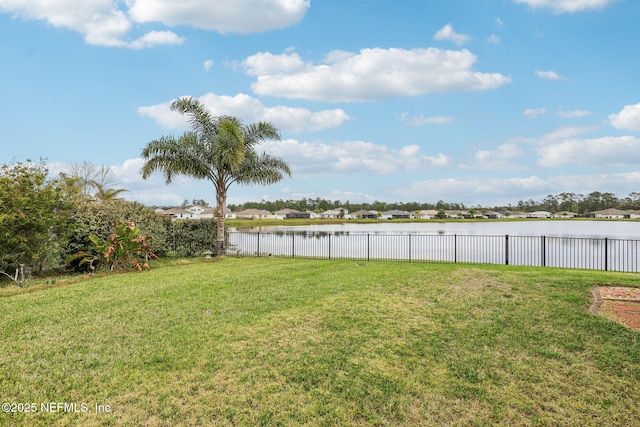 view of yard featuring a water view and fence