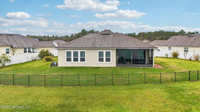 back of house featuring a lawn, a shingled roof, a fenced backyard, and stucco siding