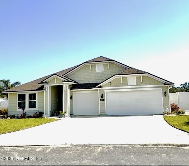 view of front of property featuring concrete driveway, an attached garage, fence, and a front lawn