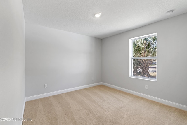 carpeted empty room with a textured ceiling