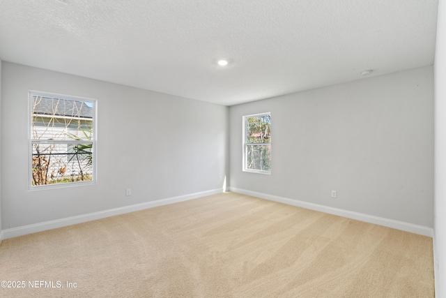 carpeted empty room featuring a textured ceiling