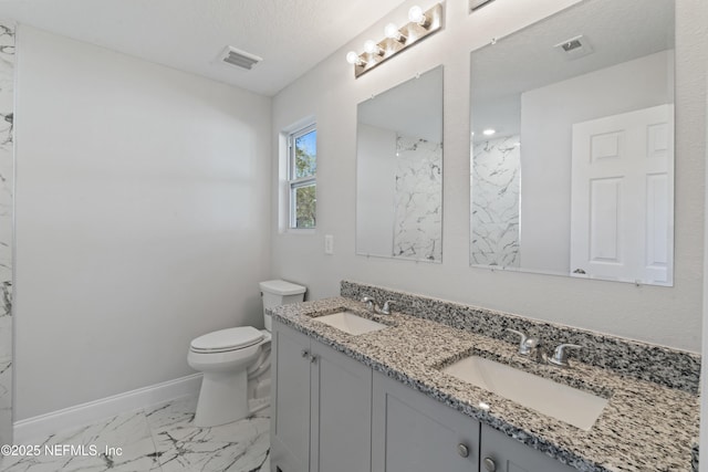 bathroom with vanity, toilet, and a textured ceiling