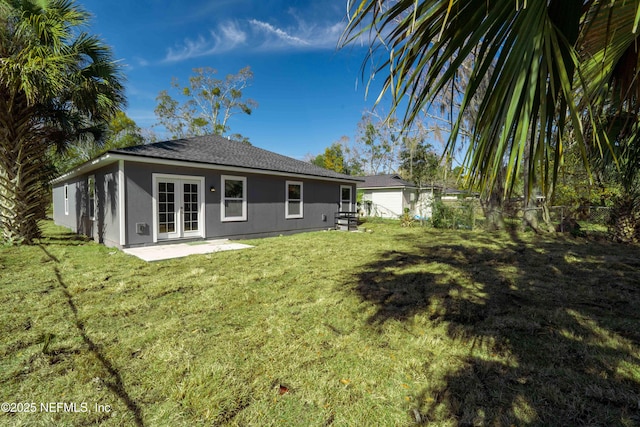 back of house with french doors, a patio area, and a lawn