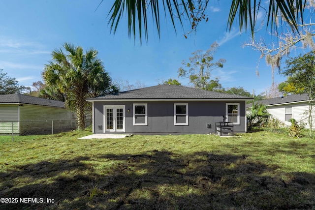 back of house featuring french doors and a lawn