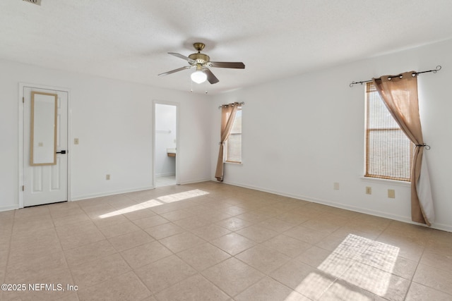 empty room featuring a wealth of natural light, a textured ceiling, and ceiling fan