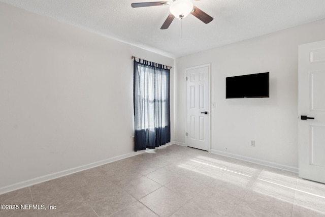 unfurnished room with ceiling fan and a textured ceiling