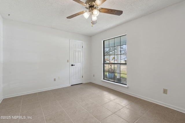 tiled empty room with ceiling fan and a textured ceiling