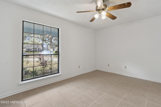 tiled empty room with ceiling fan and a textured ceiling