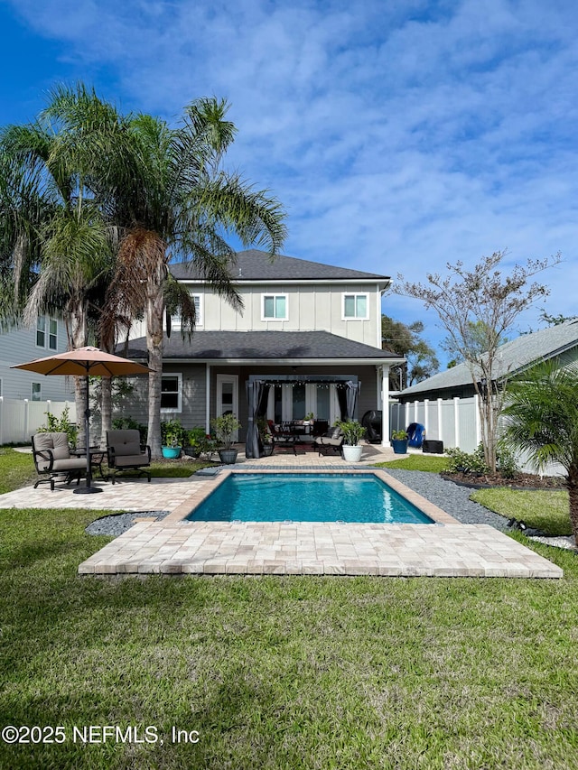 rear view of house with a lawn and a patio area