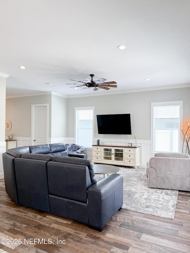 living room featuring crown molding, plenty of natural light, and hardwood / wood-style flooring