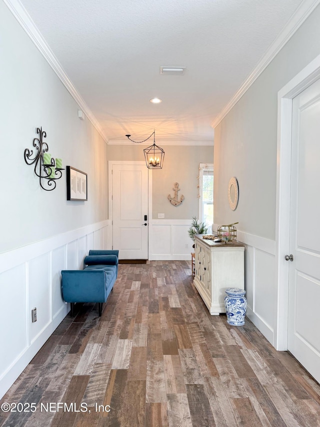 interior space featuring hardwood / wood-style flooring, crown molding, and a chandelier